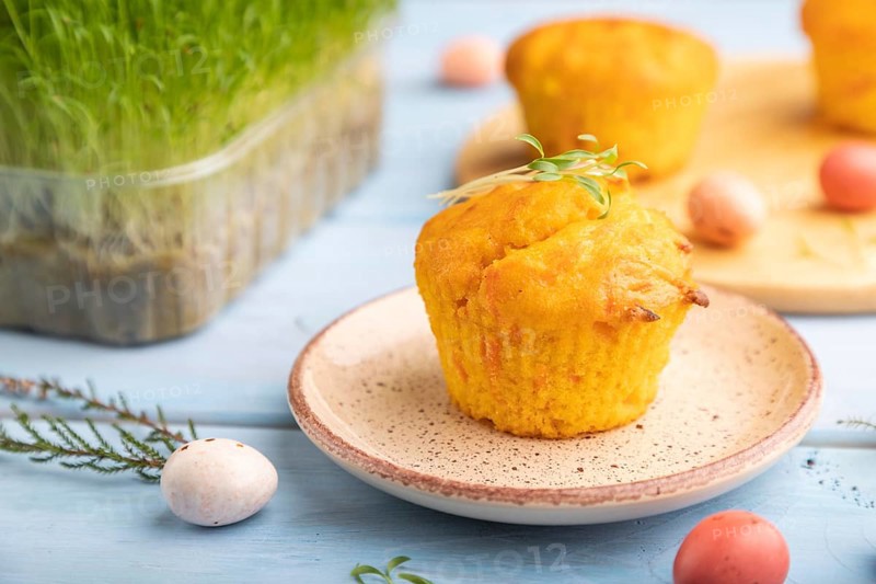 Homemade cakes with chocolate eggs and carrot microgreen on a blue wooden background. side view, close up, selective focus