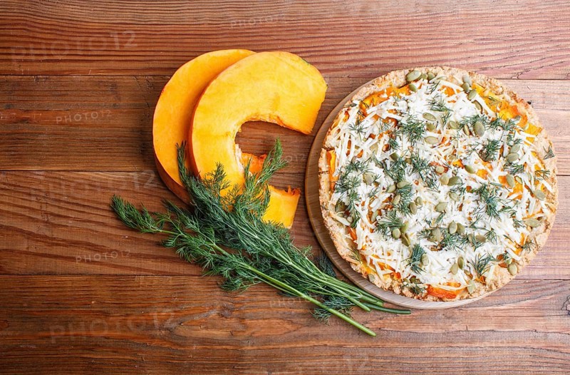 Sweet pumpkin pie with cheese and dill on brown wooden background. top view. copy space