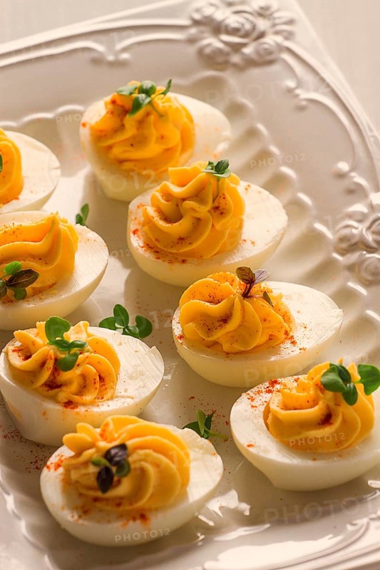 Boiled eggs stuffed with yolk with mayonnaise, on a white plate, selective focus, blurry, close-up, no people