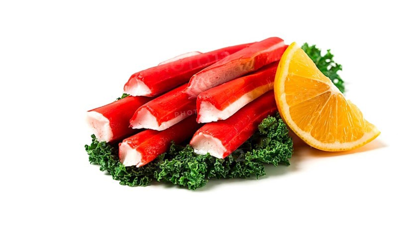 Fresh crab sticks, on Kale leaves, lemon slice, on a white background, horizontal, no people, selective focus