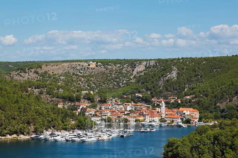 Marina plus commercial and residential buildings with traditional terracotta clay roof tiles in Skaradin town on edge of the Krka river taken from Krka belvedere in late summer, Dalmatian Coast, Croatia, Europe