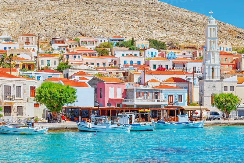 View of Emporio harbour and Saint Nicholas church in the distance, Halki Island, Dodecanese Islands, Greece, Europe