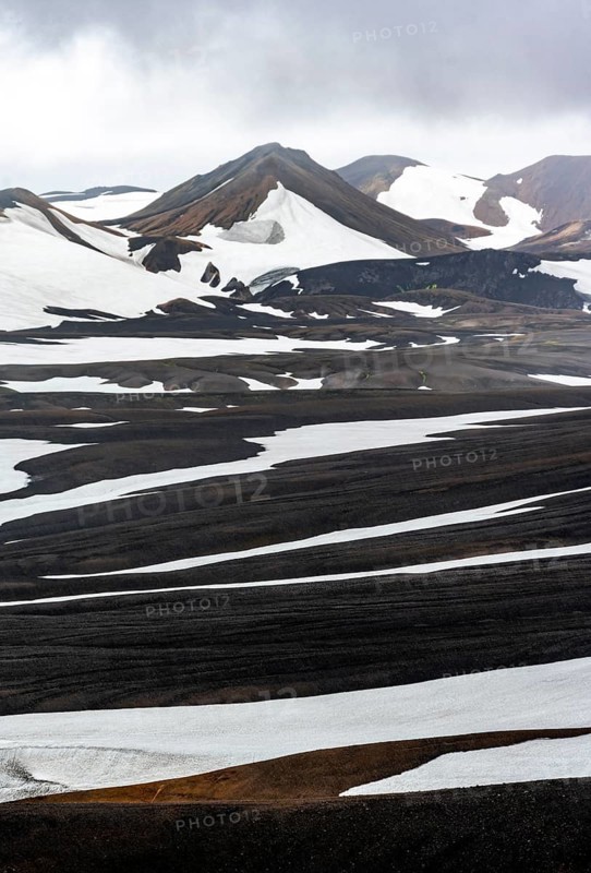Dramatic volcanic landscape with mountains and snow, at Höskuldsskáli hut in Hrafntinnusker, Laugavegur trekking trail, Landmannalaugar, Fjallabak Nature Reserve, Suðurland, Iceland, Europe