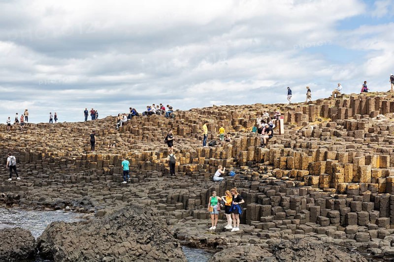 Groups of people on an impressive rock formation on the coast, Giant Causeway