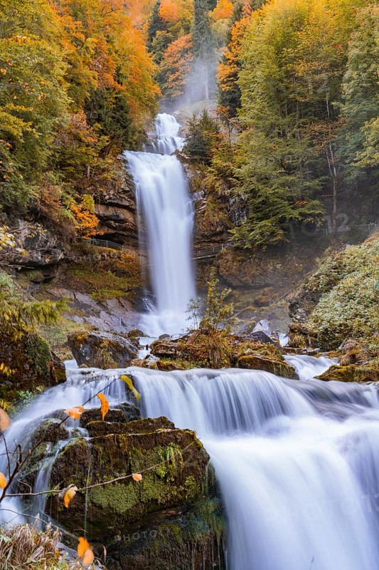 A rushing waterfall in autumn forest with vibrant colours, Giesbach waterfalls, Lake Brienz, Switzerland, Europe