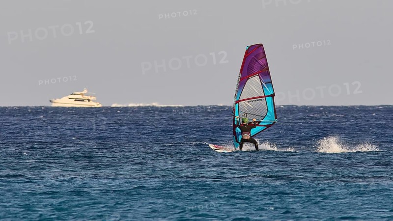 Windsurfer near a yacht in the middle of the blue sea, windsurfer, Meltemi windsurfing spot, Devils Bay, Paralia Vatha, Vatha Beach, south-east coast, Karpathos, Dodecanese, Greek Islands, Greece, Europe