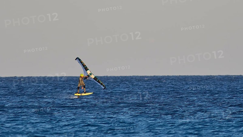 Wingfoiller, single kitesurfer over the waves of the calm sea, windsurfer, Meltemi windsurfing spot, Devils Bay, Paralia Vatha, Vatha Beach, south-east coast, Karpathos, Dodecanese, Greek Islands, Greece, Europe