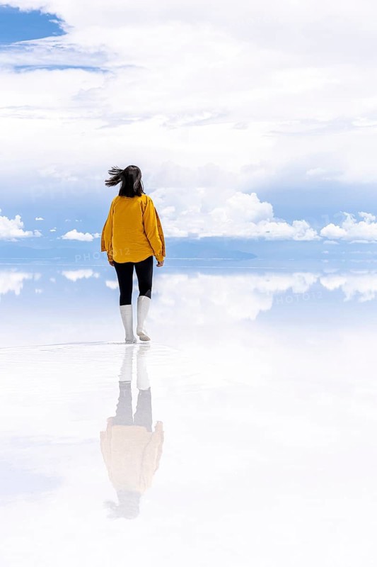 Young woman walks across the Uyuni salt lake, Salar de Uyuni, Uyuni, Bolivia, South America