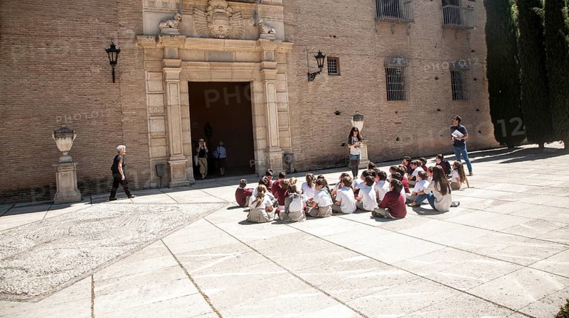 School children listen to their teacher on an educational visit to the historic sites of Granada, Spain, Europe