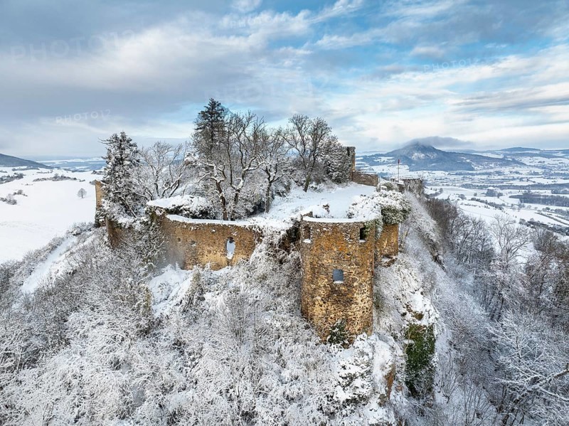 Aerial view of the snow-covered Hegau volcano Mägdeberg with remains of a castle wall on a cold winter morning, on the horizon the neighbouring Hegau volcano Hohenhewen, district of Constance, Baden-Württemberg, Germany, Europe