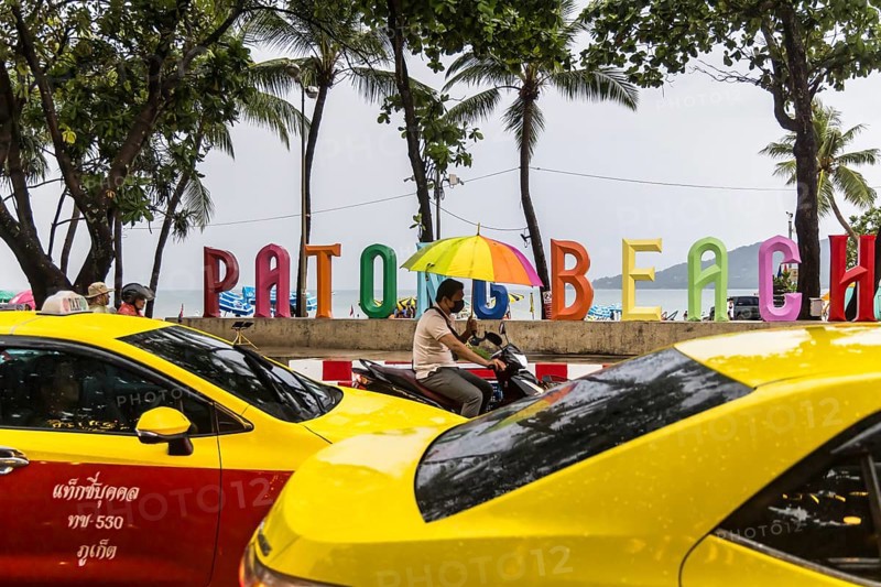 Patong Beach in rainy weather. A photo spot with coloured letters on the beach. Taxis and colourful umbrella. Patong, Kathu, Phuket Island, Thailand, Asia