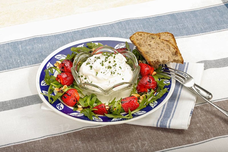 Swabian cuisine, Luggeles cheese with strawberries and salad rocket, Swabian cream cheese, dairy product, vegetarian, healthy, rocket, bread, chives, arranged on a plate, grandmother's kitchen, regional, home cooking, typical Swabian, traditional cuisine reinterpreted, food photography, studio, Germany, Europe
