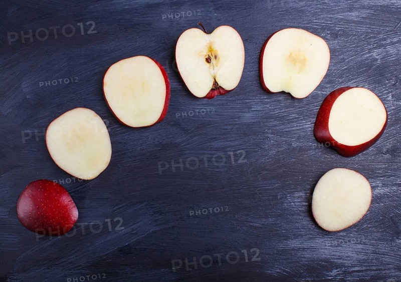 Sliced red apple on black wooden background. closeup. top view, copyspace