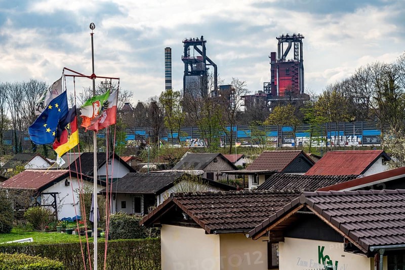 Allotment gardens along the A42 motorway, Emschertal allotment garden association, Emscherschnellweg, in Duisburg-Beeck, noise barrier, view of the ThyssenKrupp Steel Bruckhausen steelworks, blast furnaces 5 and 6, Duisburg, North Rhine-Westphalia, Germany, Europe