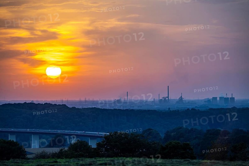 Sunset over the western Ruhr area, Ruhr valley bridge of the A52 motorway between Essen and Mülheim/Ruhr, behind the Krupp Mannesmann steelworks, HKM in the south of Duisburg, blast furnaces, North Rhine-Westphalia, Germany, Europe