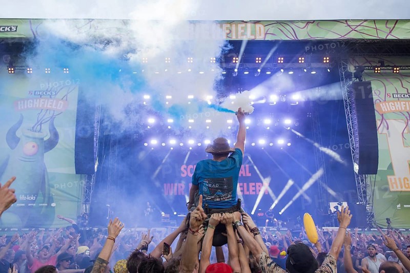 A wheelchair user with pyro in his hand is carried over the audience during the performance of the band Feine Sahne Fischfilet at the Highfield Festival on Saturday, Störmthaler See, 17/08/2024