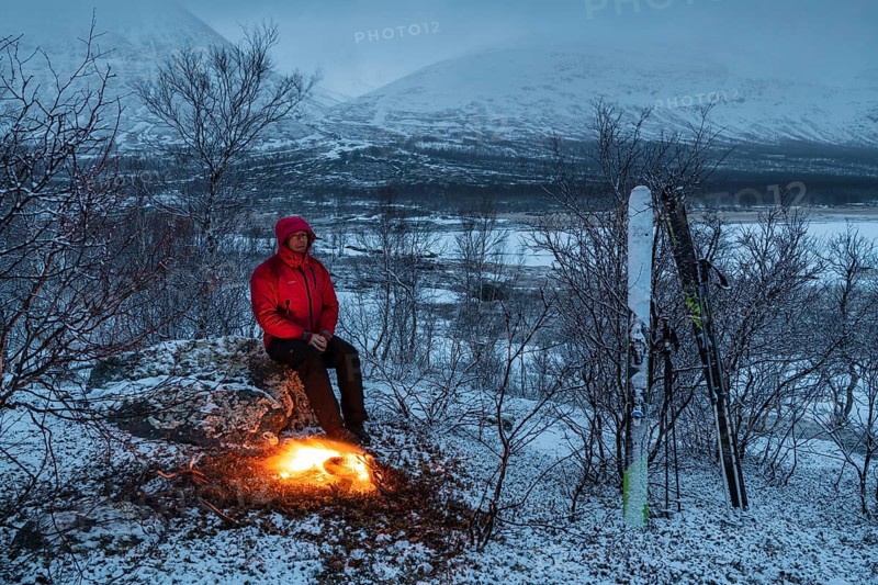 Man at the campfire, Stora Sjöfallet National Park, World Heritage Laponia, Norrbotten, Lapland, Sweden, April 2018, Lapland, Sweden, Europe