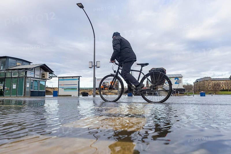 Due to the heavy precipitation in the form of snow and rain, alert level 3 has been declared on the Elbe in Dresden. The maximum level is expected to be 6.37 metres on 29.12.2023. The Terrassenufer was closed due to flooding and the first flood protection barriers were installed. Cyclists on the flooded Terrassenufer, Dresden, Saxony, Germany, Europe