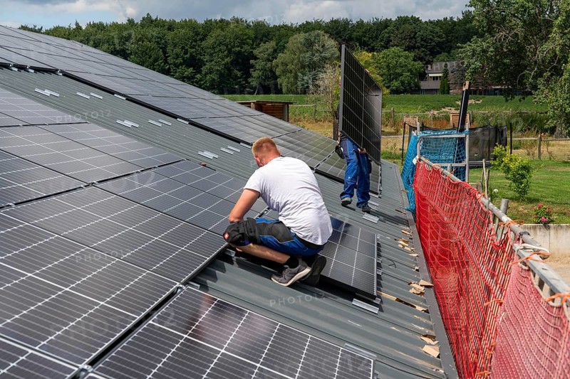 Installation of solar modules on the roof of a barn on a farm, over 210 photovoltaic modules are installed on the roof, North Rhine-Westphalia, Germany, Europe