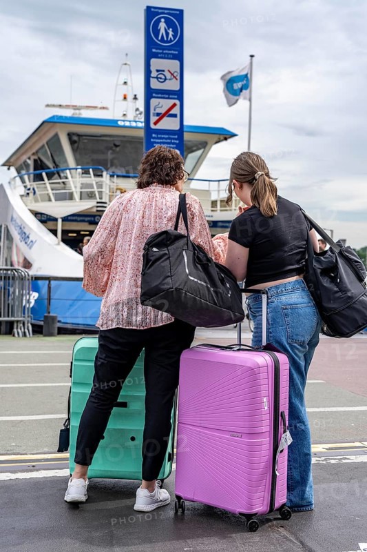 Tourists with luggage, wheeled suitcases, at Amsterdam Centraal railway station, Netherlands
