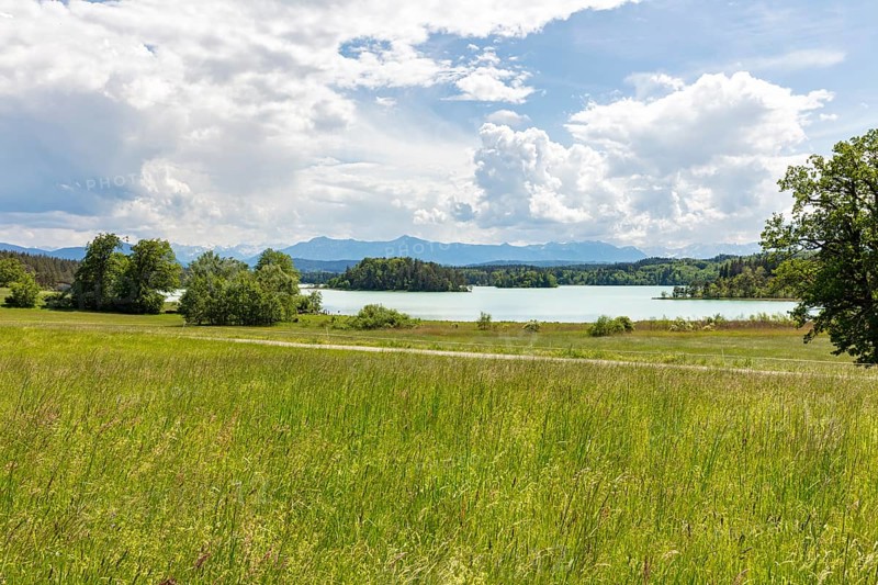 Extensive meadow landscape with a lake and mountains on the horizon under a cloudy sky, Easter Lakes
