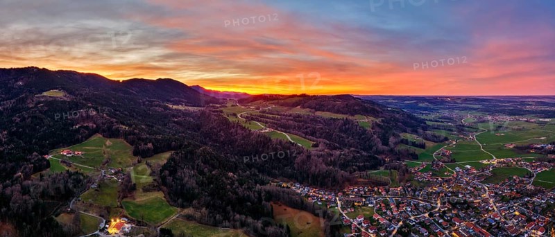 Evening mood over a village with hills and valleys at sunset, brightly coloured sky, Bad Feilnbach