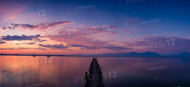 Panoramic photo, Illuminated clouds over sailing boats and jetty on Lake Chiemsee at dawn, behind the Chiemgau Alps, Chiemgau, Upper Bavaria, Bavaria, Germany, Europe