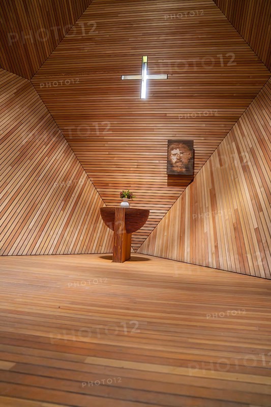 Modern interior of a wooden church with an altar table, flowers and a cross, minimalist design, Penken, Zillertal, Austria, Europe