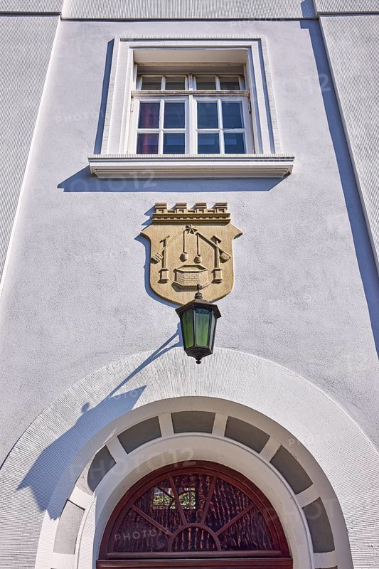 Facade of a whitewashed house in the classicist style with the coat of arms of the salt boiling trade, window and lantern in Bad Salzuflen, Lippe district, North Rhine-Westphalia, Germany, Europe
