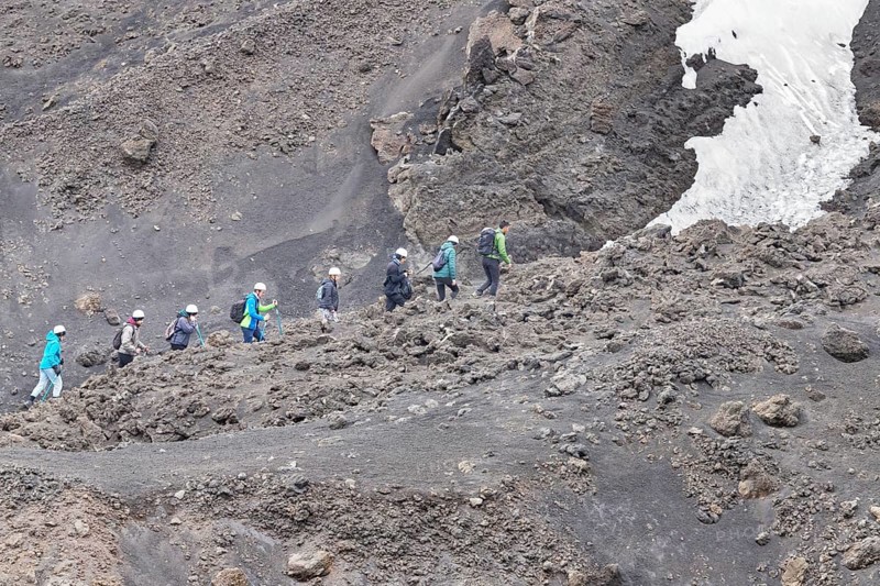 Group of hikers walking up to Mount Etna summit, Etna, Sicily, Italy, Europe
