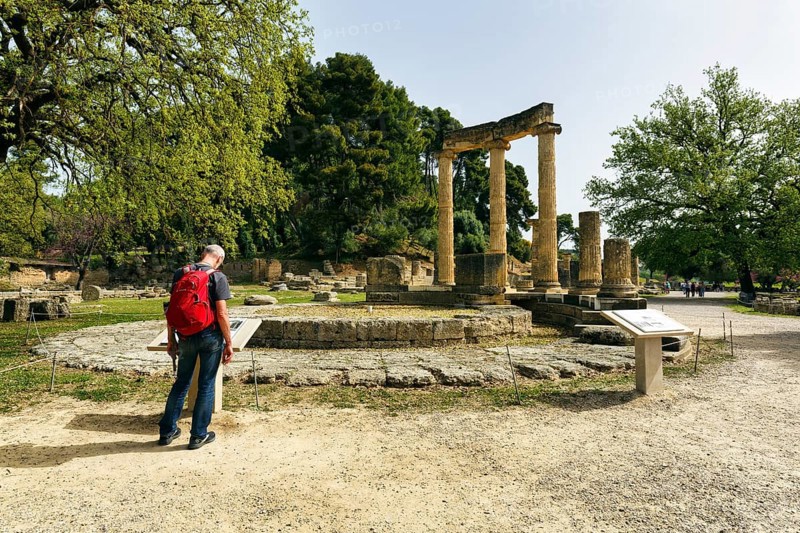 Hiker, tourist at the Philippeion, restored ruins, rotunda, ancient Olympia in spring, archaeological site, sanctuary of Zeus, UNESCO World Heritage Site, Elis, Peloponnese, Greece, Europe