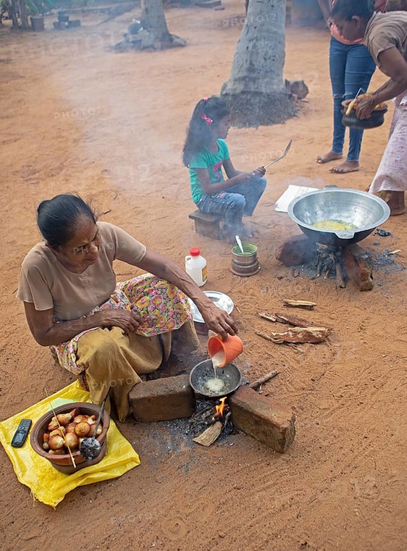 Sri Lankan woman, 63 years old, frying traditional doughnuts on a fire on the ground, Sella Kataragama, Kataragama, Uva Province, Sri Lanka, Asia