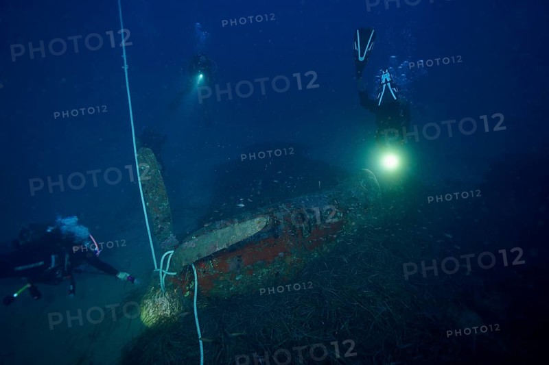 Divers illuminate an aircraft wreck from the Second World War during an underwater exploration, dive site aircraft wreck Mustang P51, Giens peninsula, Provence Alpes Côte d'Azur, France, Europe