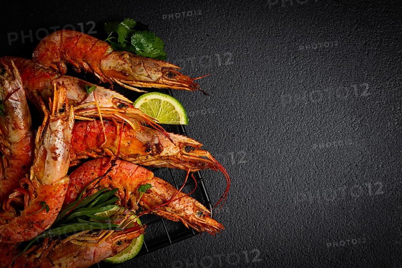 Langoustines, Australian, freshly frozen on ice, top view, lime and greens