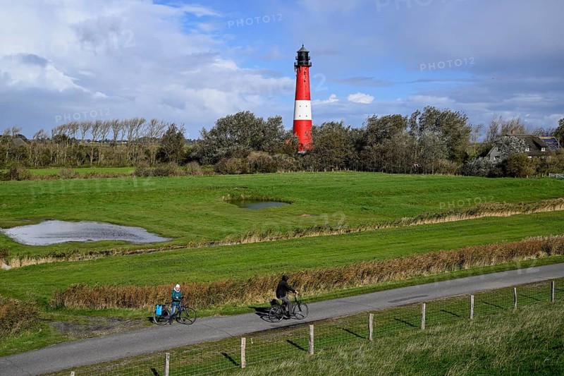 Cyclist in front of the lighthouse from 1906, island of Pellworm, Schleswig-Holstein Wadden Sea National Park, North Frisia, Germany, Europe