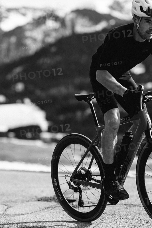 Road bike rider in spring in the Allgäu against the picturesque backdrop of the Alps, Bavaria, Germany, Europe