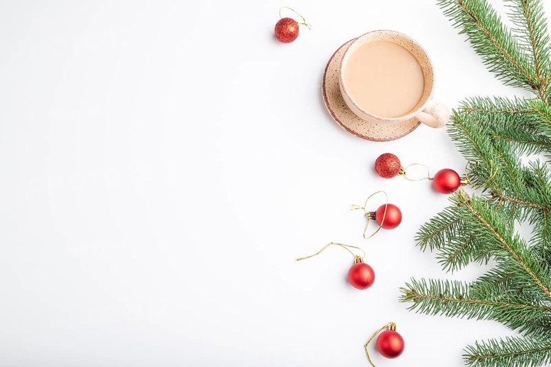Christmas or New Year composition. Decorations, red balls, fir and spruce branches, cup of coffee, on a white paper background. Top view, copy space, flat lay