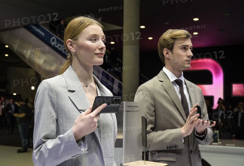Models present the HONOR Magic V2 RSR foldable smartphone at the trade fair stand, MWC Mobile World Congress 2024, Barcelona, Spain, Europe