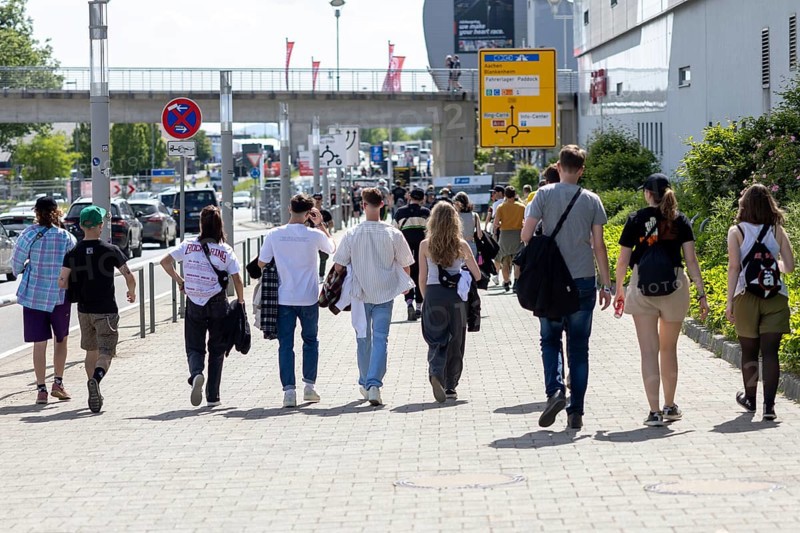 Adenau, Germany, 8 June 2024: Fans on their way from one of the Rock am Ring campsites to the festival site. The festival takes place at the Nürburgring race track near the town of Adenau from 7 to 9 June 2024, Europe