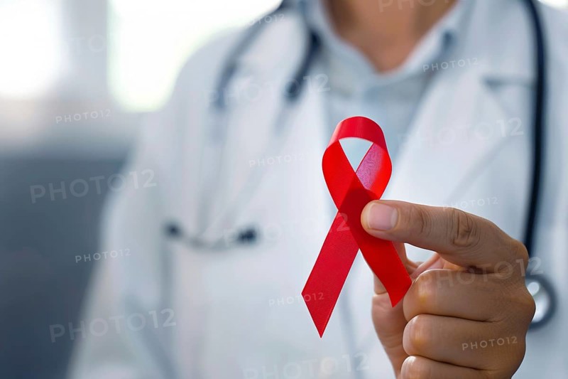 Red AIDS awareness ribbon held by doctor's hand. Generative AI, AI generated