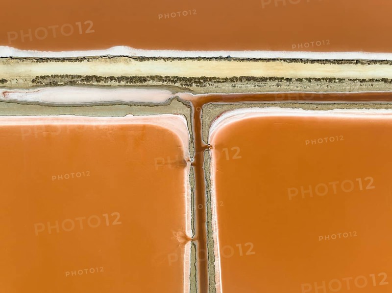 Saline ponds at the Bonanza salt works near Sanlúcar de Barrameda. The orange-red colour depends on the level of salinity and is directly caused by the algae Dunaliella salina and brine shrimp. Aerial view. Drone shot. Cádiz province, Andalusia, Spain, Europe