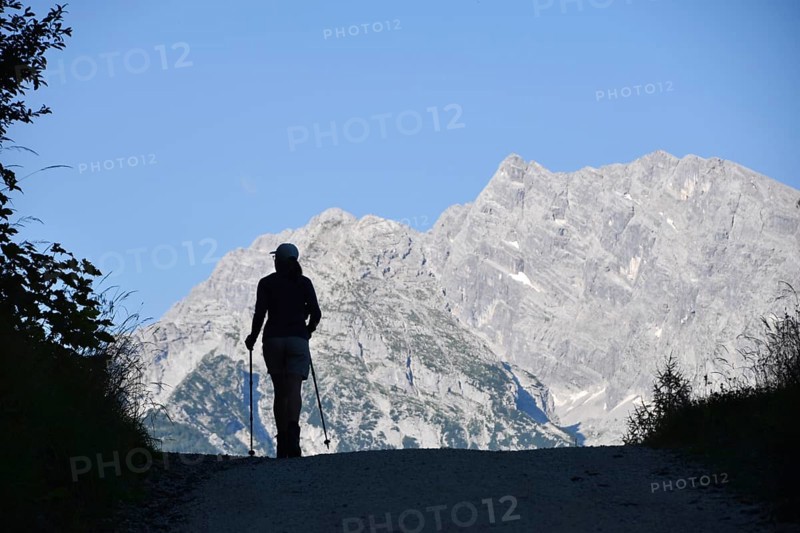 Single woman on a hike in the Berchtesgaden National Park with the Watzmann and the Watzmann east face as a backdrop, Bavaria, Germany, Europe