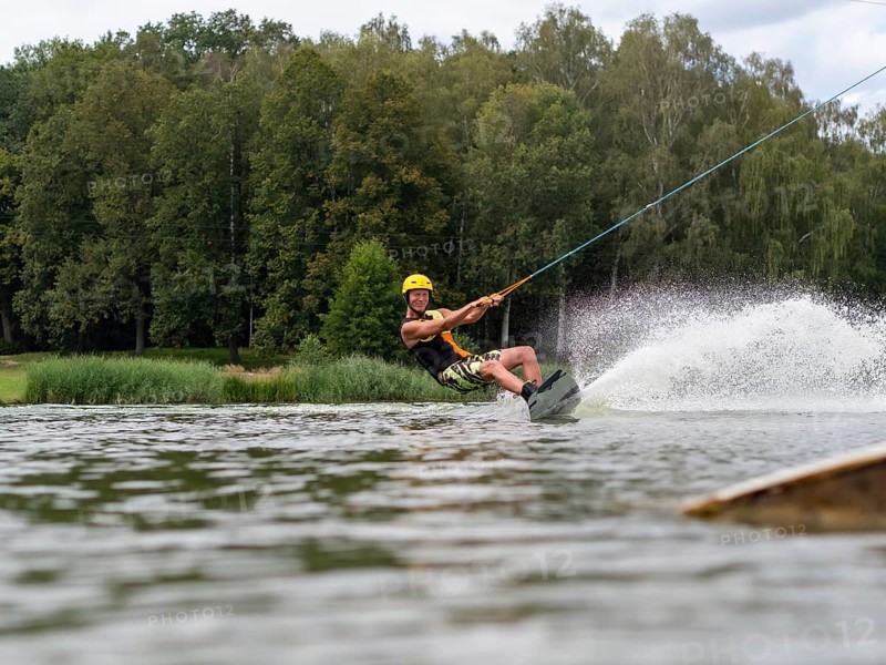Sporty man with wakeboard, water sports, water skiing and wake park