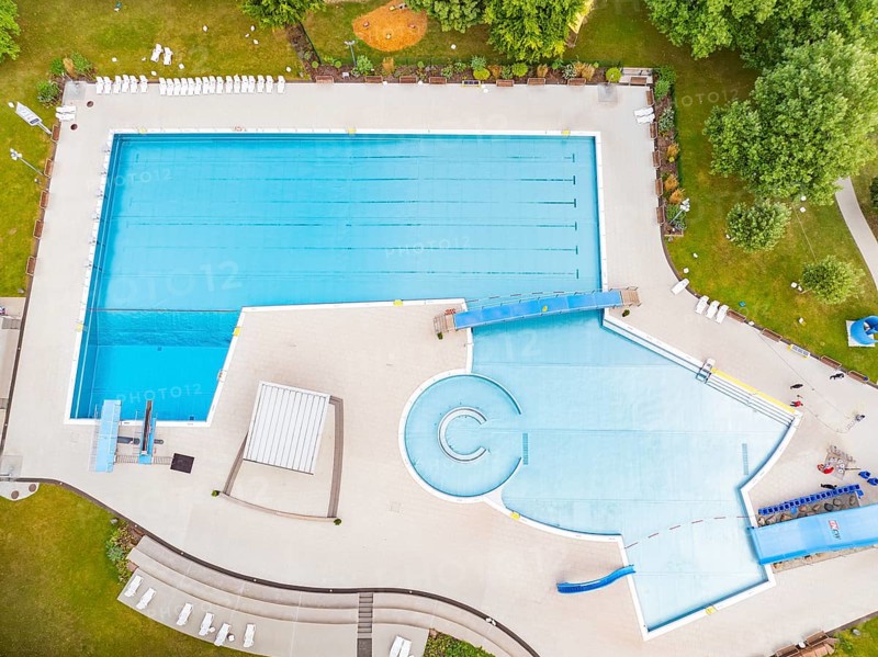 Aerial view of an outdoor swimming pool with a large swimming pool and water slide, surrounded by trees, outdoor swimming pool Calw, Black Forest, Germany, Europe