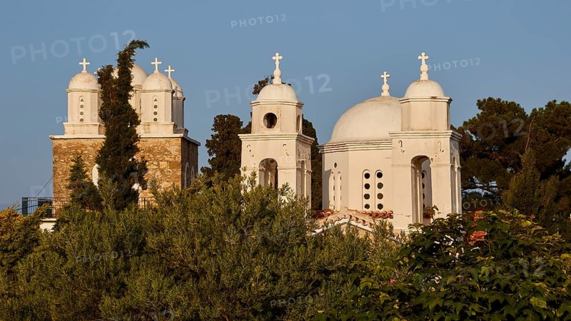 White church with three domes and bell towers, surrounded by greenery under a clear sky, Koroni, Byzantine fortress, nunnery, Peloponnese, Greece, Europe