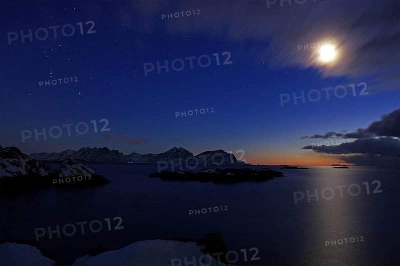 Dark coastal landscape at dusk with snow-covered islands, moon, stars and few clouds, winter, Nyksund, Langoya, Vesteralen, Nordland, Norway, Europe