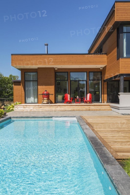 Modern cube style home with stained horizontal wood cladding and in-ground swimming pool, Quebec, Canada, North America