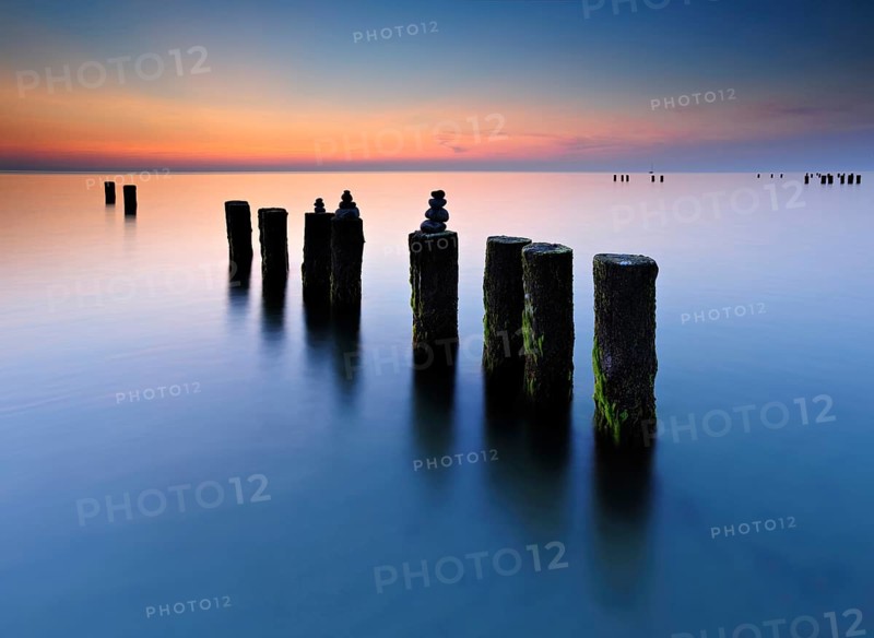 Stone pyramids on old groynes with algae in the water on the beach of the Baltic Sea, long exposure at sunset, Wustrow, Fischland-Darß-Zingst peninsula, Mecklenburg-Vorpommern, Germany, Europe