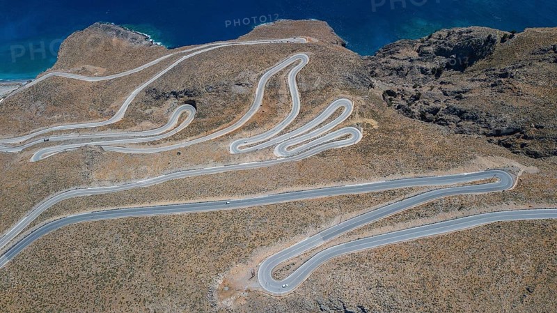 Aerial view of pass road serpentines from to Passo Anopoli above south coast of Crete at top of picture edge Libyan Sea Mediterranean near Sfakia, Chora Sfakion, Crete, Greece, Europe