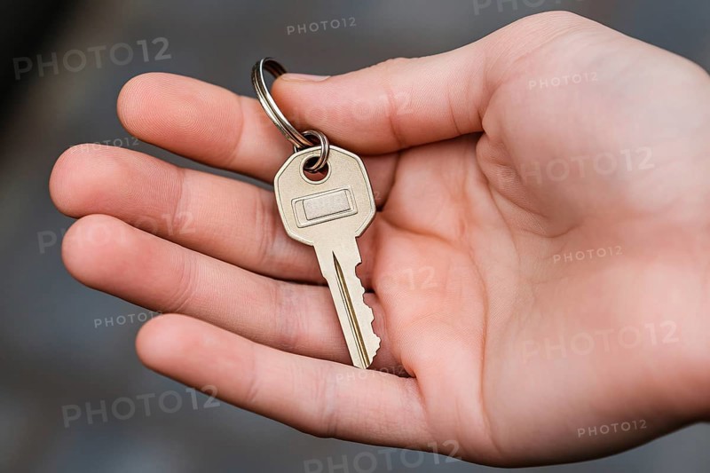 Person's hand holding single house key. Generative AI, AI generated